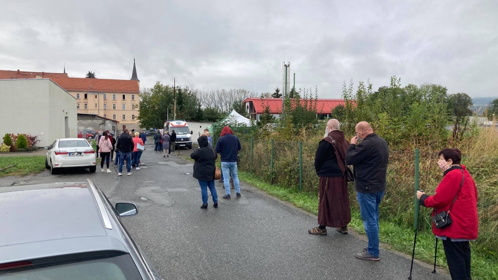 Oblężony wymazobus, pacjenci czekają w deszczu - Zdjęcie główne